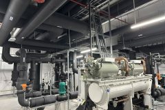 Chiller ze sprężarkami śrubowymi w maszynowni z izolowanymi rurociągami wody lodowej i pompami