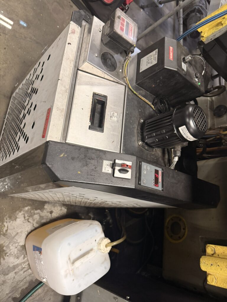 Urządzenie chłodnicze z elementami elektrycznymi i czarnym silnikiem.